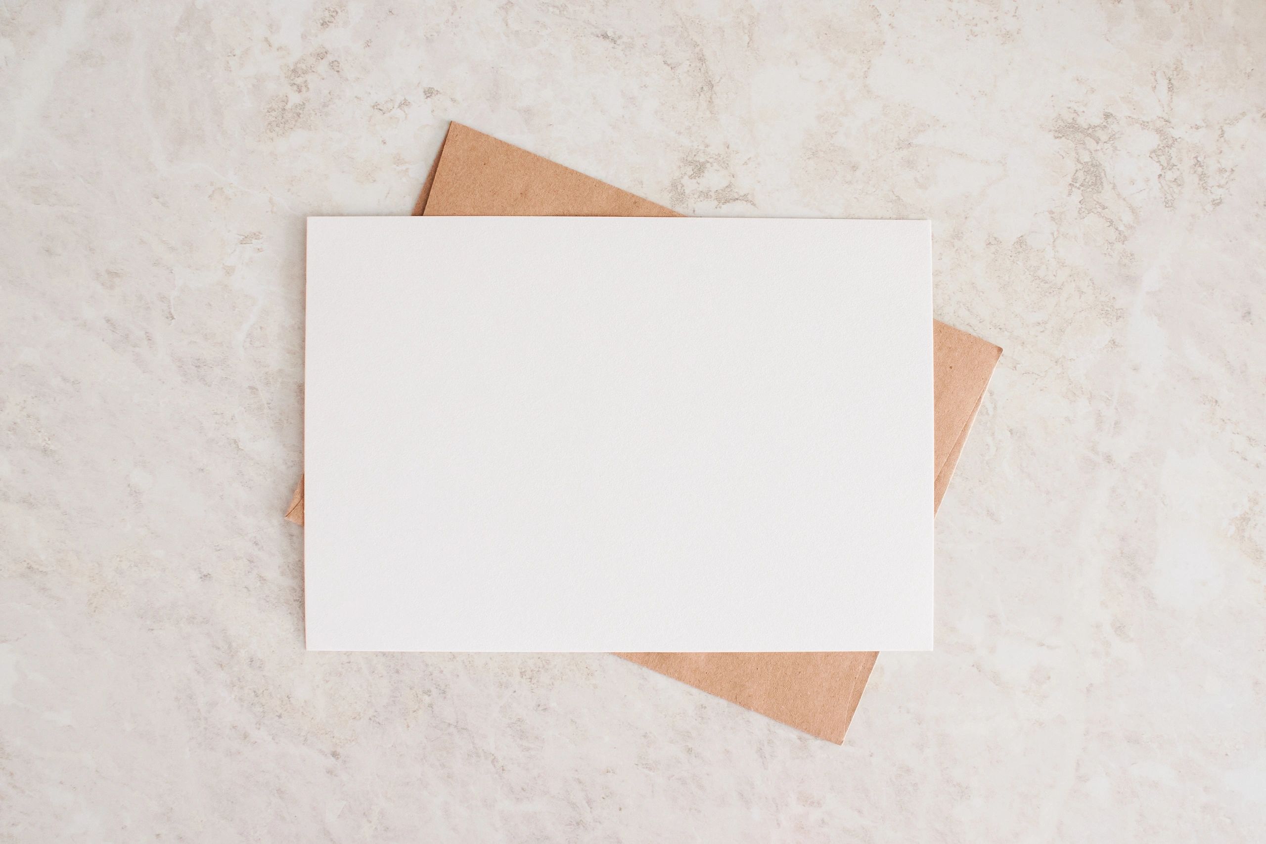 Neutral greeting card mockup with envelope on a soft beige surface