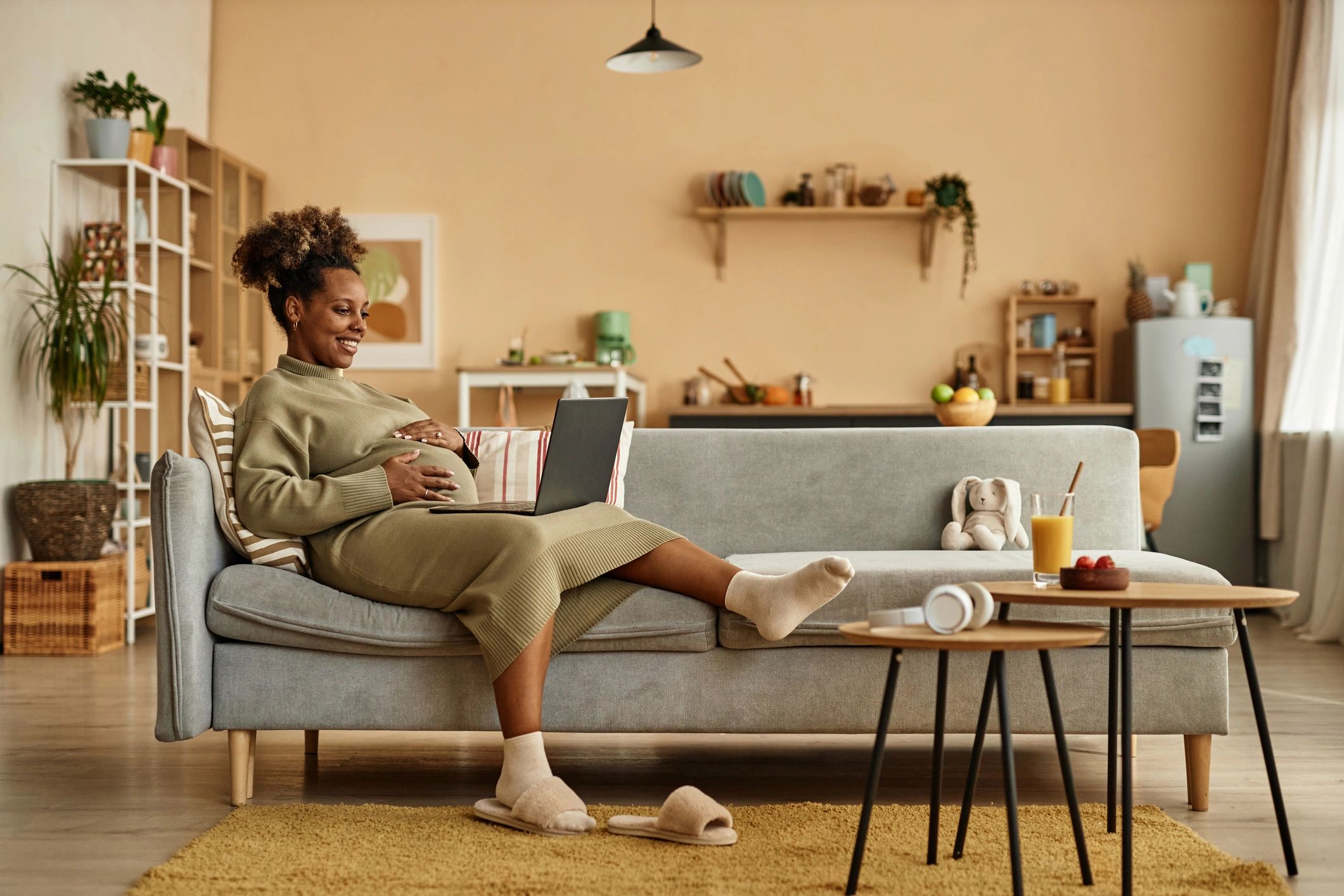 Woman relaxing on a sofa with laptop in a cozy living room