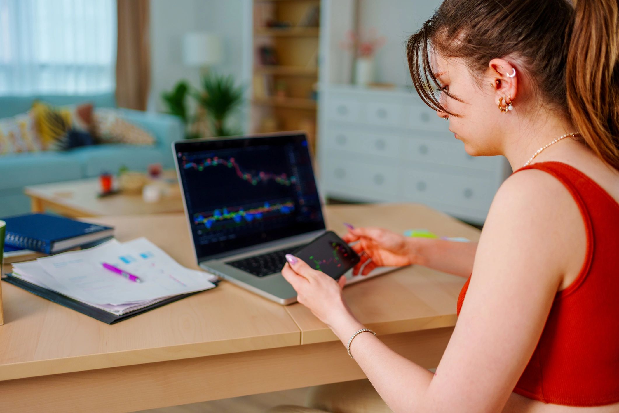 Woman working thoughtfully at a desk with laptop and notes